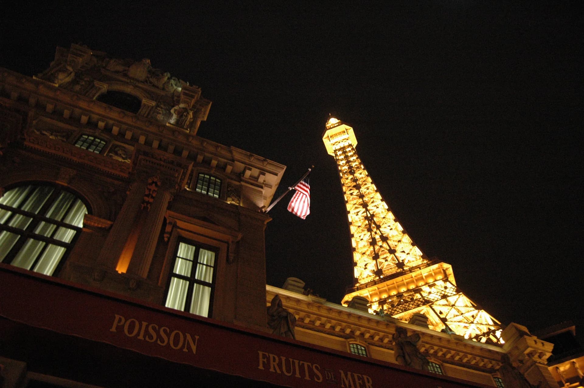 Nighttime exterior view of the Paris Las Vegas Eiffel Tower replica, seen from the Mon Ami Gabi side of the resort.